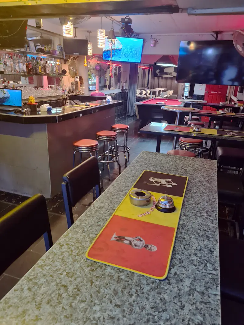 Panoramic view of the interior: tables, sports screens, and Belgian decor.