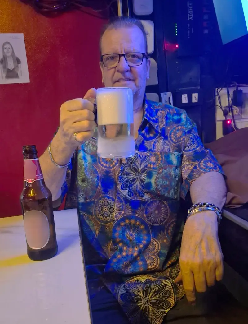 Le patron du Brussels Bar à Pattaya présentant un verre de bière belge pour trinquer.